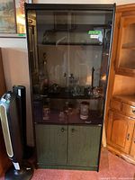 Full view of cabinet showing glass display upper section and lower green doors