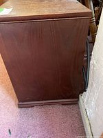 Side view of wood-finish cabinet space heater on casters