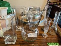 group of six clear glass vases on table
