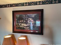 Full view of framed landscape art on wall showing frame and mats