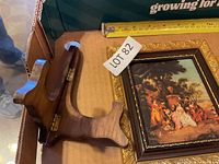 Framed classical scene and folding wood stand with ruler for scale