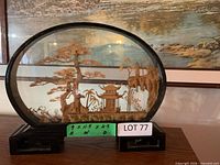 Front view of oval glass diorama showing cork scene and wood base