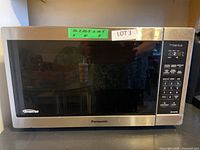 Front view of Panasonic Inverter microwave showing stainless steel trim, black window, and digital control panel