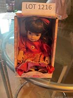 Full view of porcelain doll in floral box