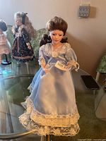 Front full-length view of porcelain doll on tabletop