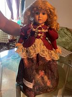 Full view of porcelain doll standing on table