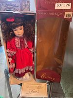 Doll in original box alongside empty outer sleeve and certificate