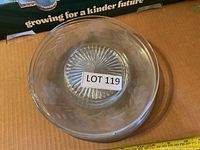 Stack of clear glass plates showing etched cornflower design and starburst base
