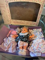 Full set in open box showing doll, outfits and accessories
