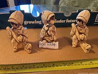 Front view of three ceramic child figurines