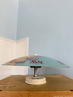 Side profile showing glass shade and white mount