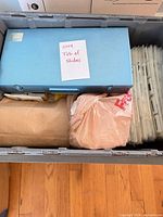 Overview showing blue metal slide case, envelope, plastic bag, stack of loose plastic-mounted slides