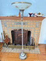 Full view of torchiere lamp in front of fireplace