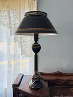 Full view of black metal table lamp on table
