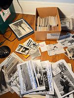 Overview of cardboard box and loose black & white photo prints spread on table
