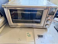 Front view of Breville Smart Oven Air Fryer Pro and manual