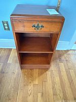 Front view showing drawer, shelves, finish, and wear