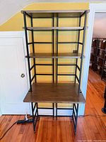 Front view of metal frame desk with four brown shelves