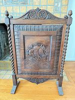 Front view of carved oak fireplace screen showing overall design and condition