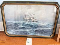 Framed maritime print showing sailing ship on ocean in wood frame