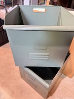 Two green metal storage bins stacked