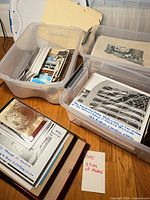 Three plastic tubs containing assorted vintage photographs and postcards