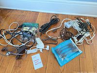 Group view of all cords, power strip, adapters and blue pouch on floor
