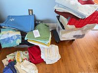 Overall lot showing stacked tablecloths and tubs