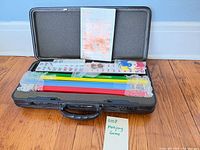 Entire mahjong set inside open black case showing racks, tiles, booklet and keys