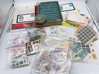 Full lot overview with album, bags of stamps, sheets, covers, tin