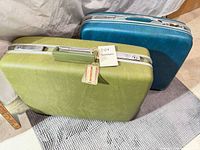 Front view of both suitcases showing colors, handles, keyed latches