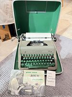 Royal portable manual typewriter in open green-lined carrying case with booklet