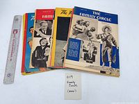 Stack of Family Circle magazines with various cover designs and a ruler for scale