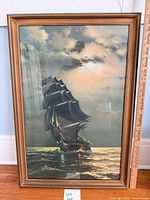 Full view of framed sailing ship print with measuring stick showing size