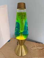 Full view of gold-tone lava lamp showing blue liquid and yellow wax in operation