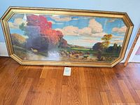 Full view of framed landscape print leaning against wall