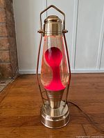 Full view of lava lamp showing base, glass vessel with red lava, and cord