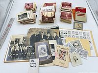 Overall lot showing assorted stacks, mounted cards, group photos and ruler for scale