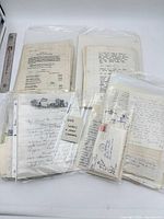 Grouped view of letters and envelopes in plastic sleeves with ruler for scale