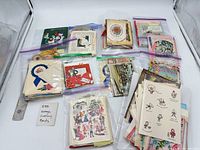 Overview of multiple stacks of vintage greeting cards and postcards in zip bags