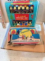 Renown 15-light box atop Supreme box with Good-Lite/Mazda box beneath