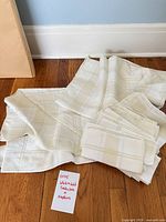 Set showing folded tablecloth and six napkins on floor