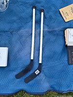 Both hockey sticks side by side on blue quilt