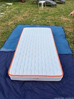 Top view of twin mattress on protective blankets outdoors