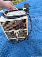 Front and side view showing grille, rust, valve knob, cord, plug, handle
