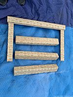 All five fabric-covered wooden valances laid out on blanket