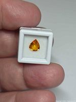 Front view of pear-cut orange sapphire in display box