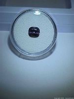 Cushion-cut purple spinel in display box, top view