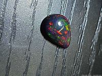 Pear cabochon Ethiopian black opal showing green and red flashes