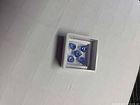 Five loose blue sapphires in gem box